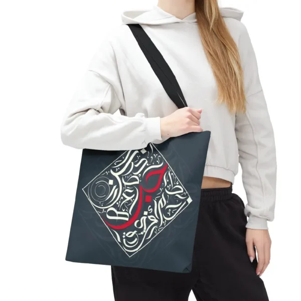 Flat lay product view of the Bedouin Love canvas tote bag featuring modern black Arabic calligraphy art on a clean background by BinMahmood.