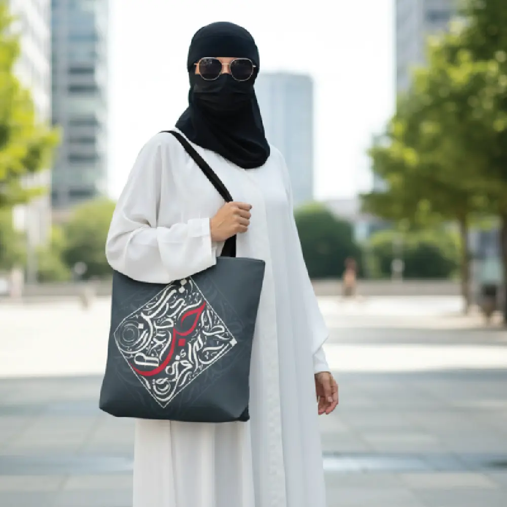 An aesthetic lifestyle model view carrying the Bedouin Love modern Arabic calligraphy tote bag over her shoulder to showcase real world size.