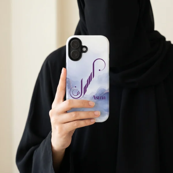 Lifestyle photography of Asma personalized Arabic calligraphy iPhone case held in hand by a model in black modest abaya