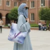 Asma calligraphy tote bag carried over shoulder, lifestyle outdoor mockup