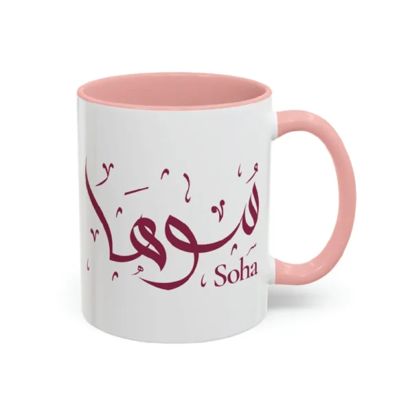 Soha name hand-crafted in Al-Wisaam Arabic calligraphy in burgundy ink on an 11oz white ceramic mug with pink two-tone accent — mouse-crafted by BinMahmood
