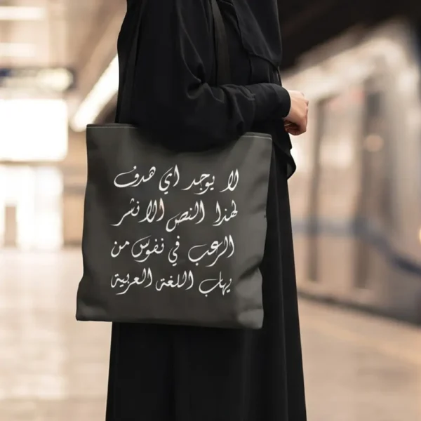 Product photoshoot of Arabic Viral Meme Tote Bag crafted in Diwani Calligraphy - the model is holding the bag shoulder down on a busy metro station - binmahmood
