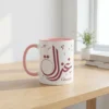 A premium lifestyle view of the Ghazala bespoke Arabic name two tone mug sitting on a light oak wooden table in a brightly lit modern study room by BinMahmood.