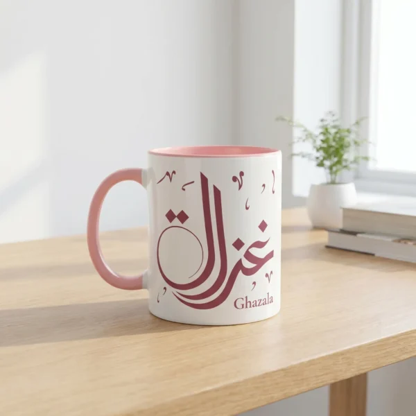 A premium lifestyle view of the Ghazala bespoke Arabic name two tone mug sitting on a light oak wooden table in a brightly lit modern study room by BinMahmood.