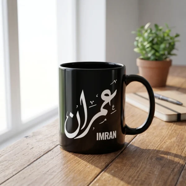 Imran personalized Arabic calligraphy black mug on a wooden table in bright natural light.