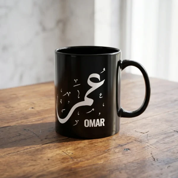 Product Photoshoot of Omar Arabic name mug in white Diwani calligraphy on black ceramic placed on an aged American Walnut table - BinMahmood