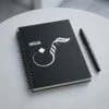 Product photography of Hasan name Arabic Sunbuli calligraphy spiral notebook placed on a table with a pen - binmahmood