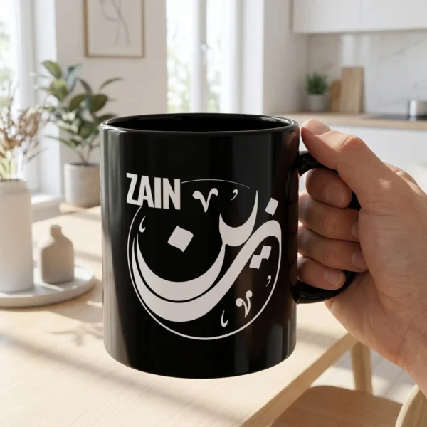 Man holding Zain Arabic name mug in black ceramic with white Diwani calligraphy and nuqta detailing, personalized Islamic gift for him